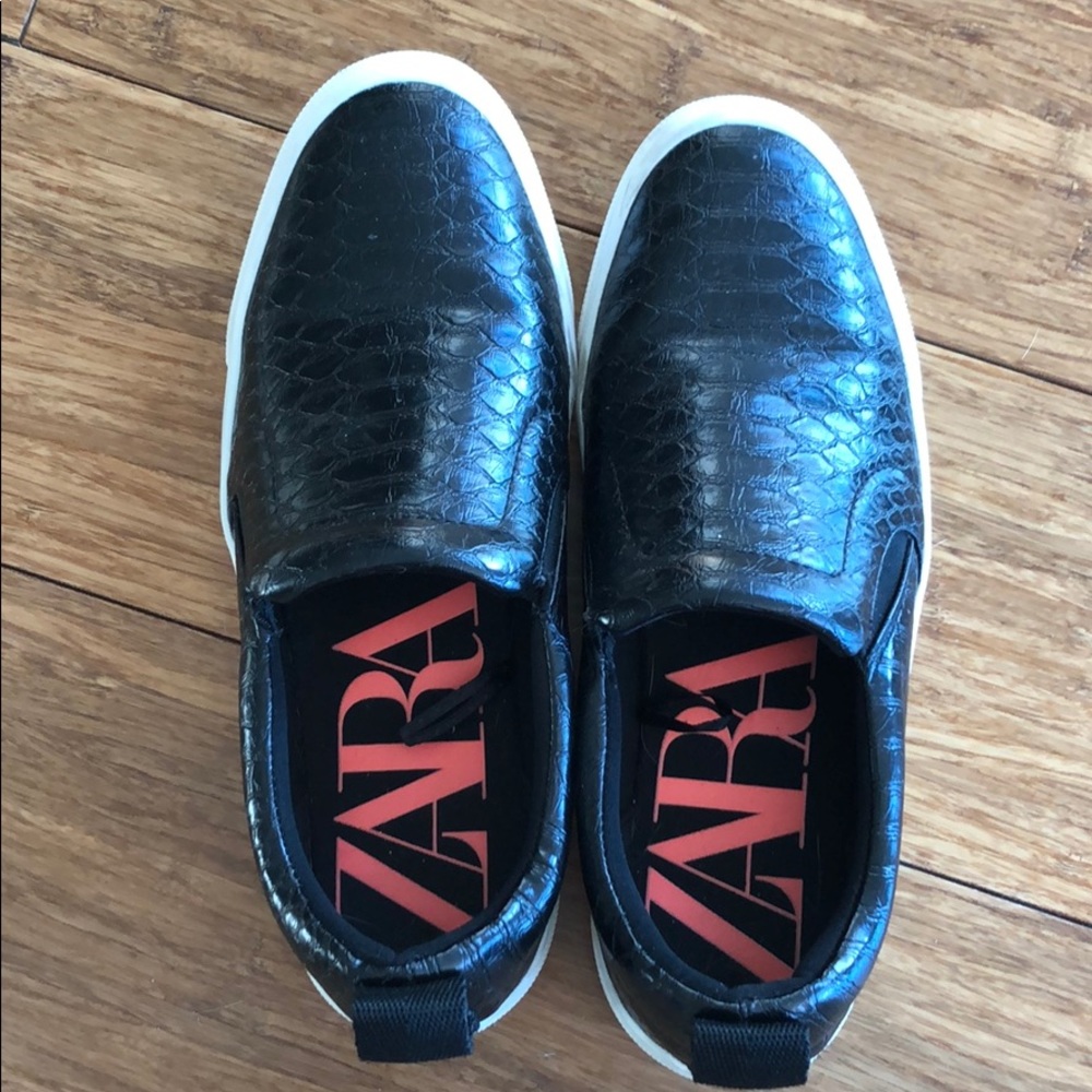 Black leather slip on sneakers.